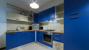 A modern kitchen with blue cabinets, a stainless steel oven, and a microwave. - Desenzanoloft – Desenzano Corte Blu Downtown (Desenzano del Garda)
