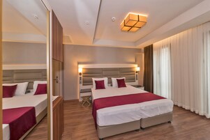 Habitación de hotel con una cama grande, una mesita de noche, un espejo y un armario.