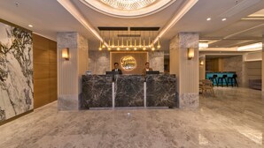 A reception area with a marble counter, a chandelier, and a sign that reads "Golden Royal." - Golden Royal Hotel & Spa (Istanbul)