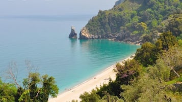 Una playa cerca, sillas reclinables de playa, sombrillas