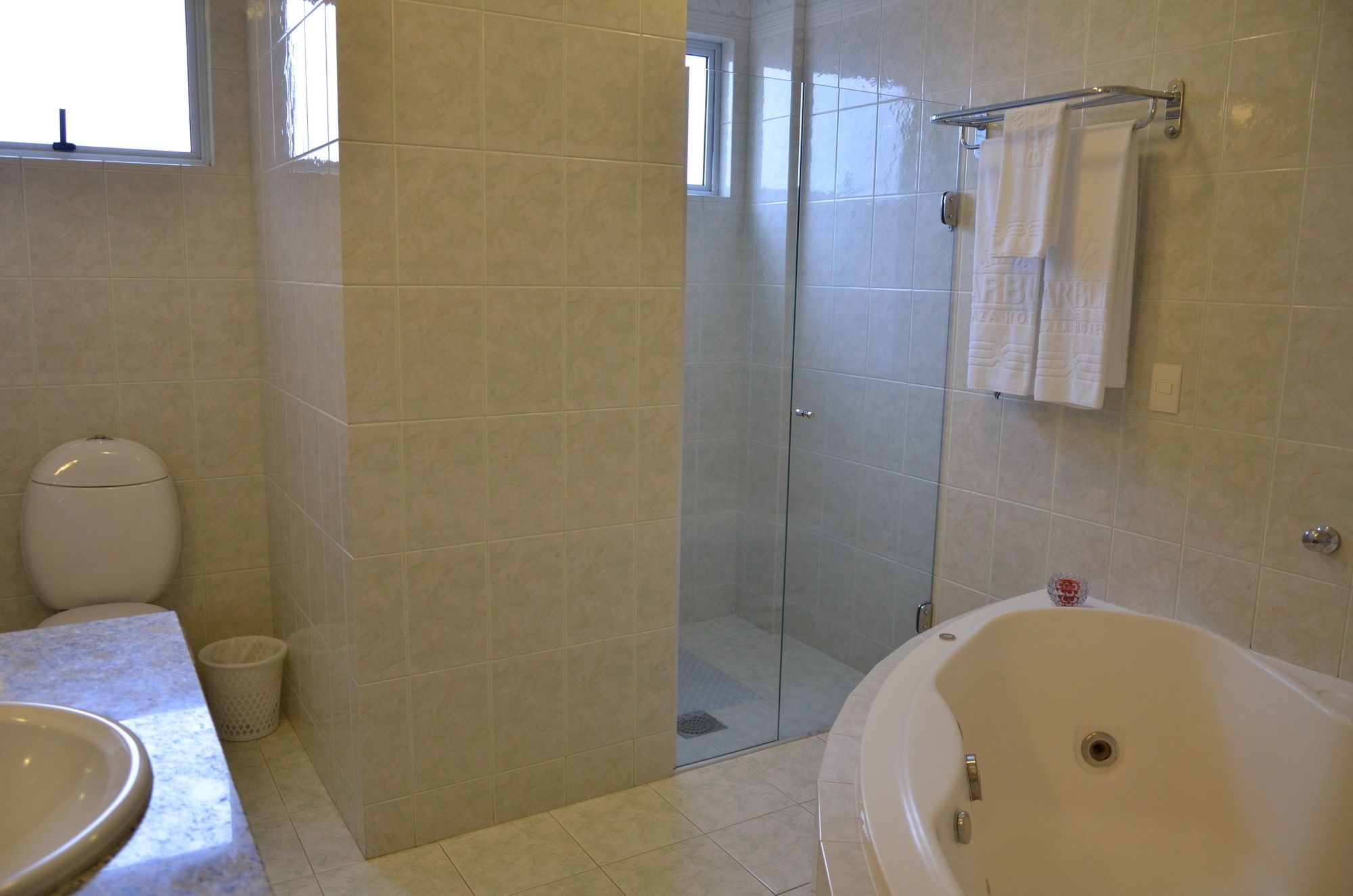 A bathroom with a toilet, sink, shower, and bathtub.