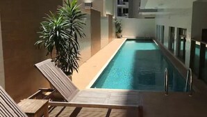 A poolside area with lounge chairs and a pool. - London Residencial Design (Niteroi)