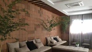 A living room with a sofa set, a coffee table, and two potted plants. - London Residencial Design (Niteroi)