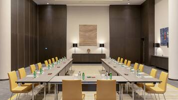 A conference room with a long table, yellow chairs, and a neutral color scheme.