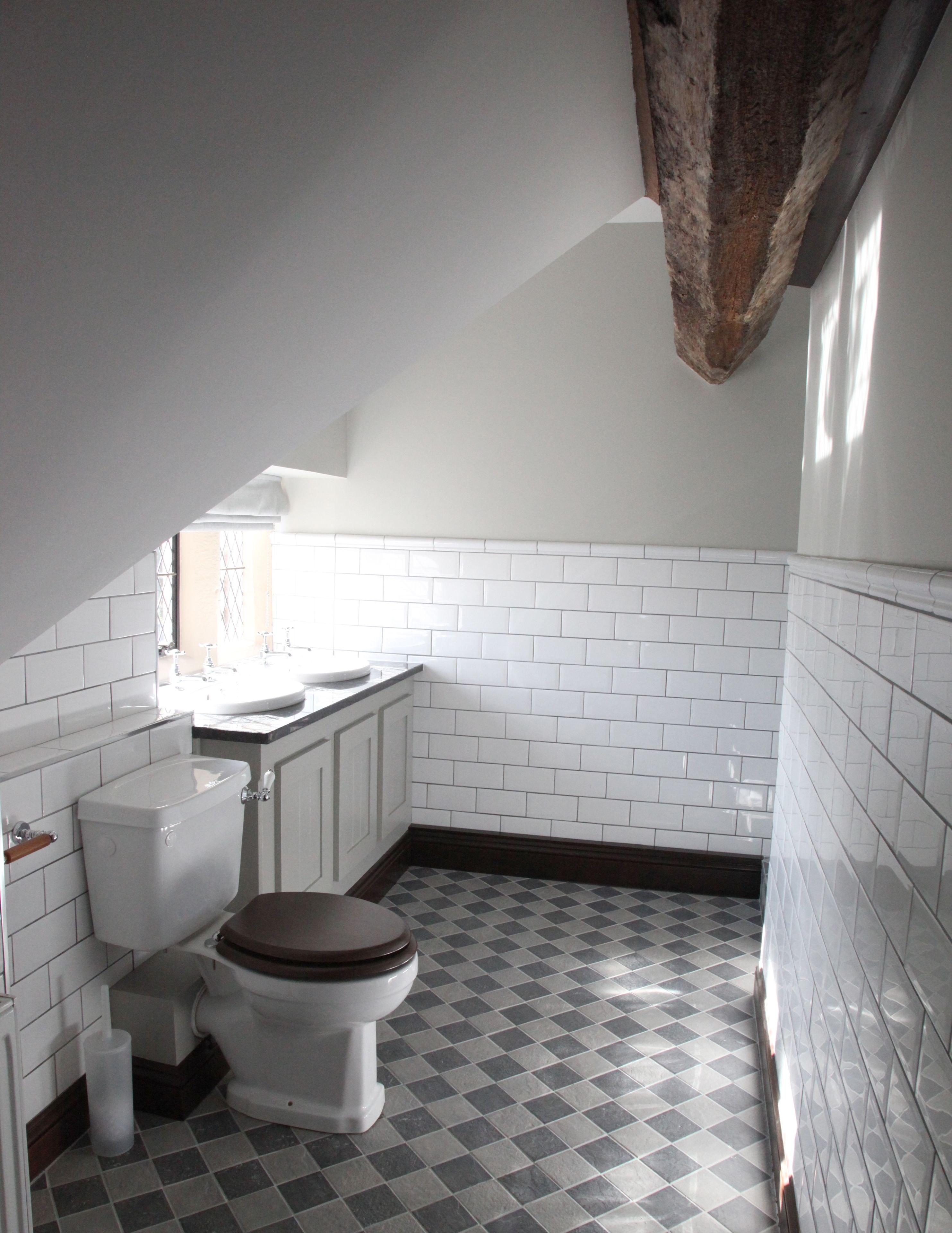 A bathroom with a white toilet, a sink, and a tiled floor.