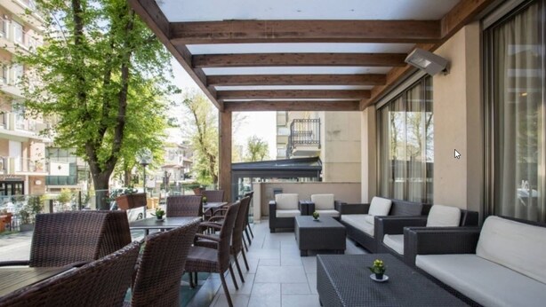 Une terrasse extérieure aménagée avec des meubles en osier, un canapé et une table.