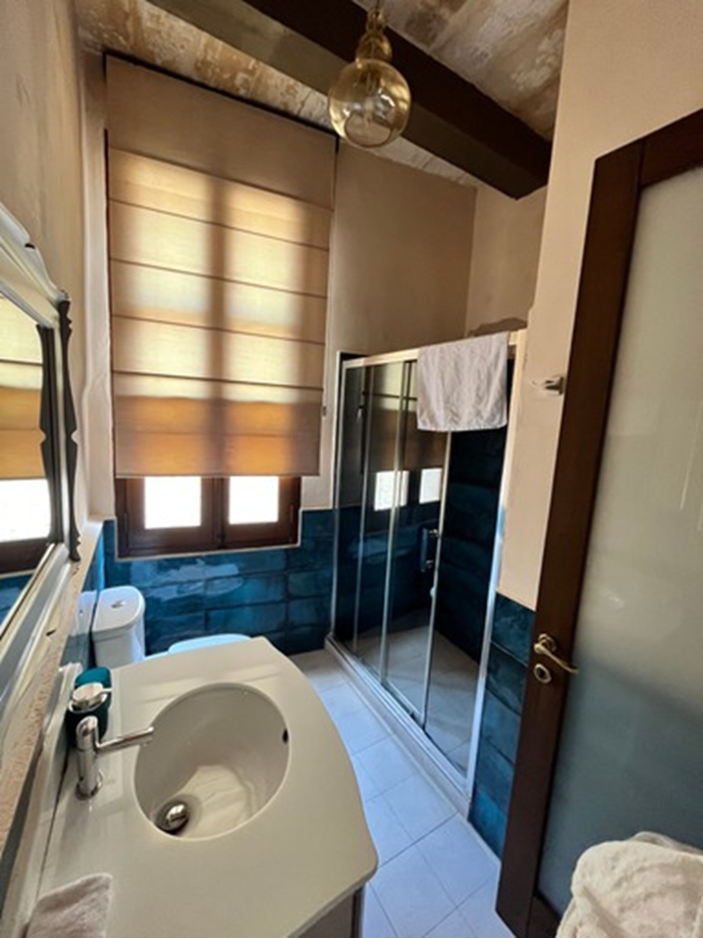 A bathroom with a bathtub, a sink, and a glass shower enclosure.