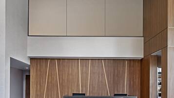 A modern reception area with a reception desk, seating, and a wooden panel wall.