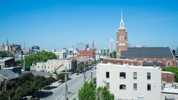 A cityscape with a prominent church steeple, various buildings, and a clear blue sky.