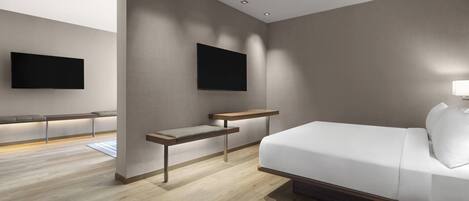 Una habitación de hotel moderna con una cama, un banco y dos televisores montados.