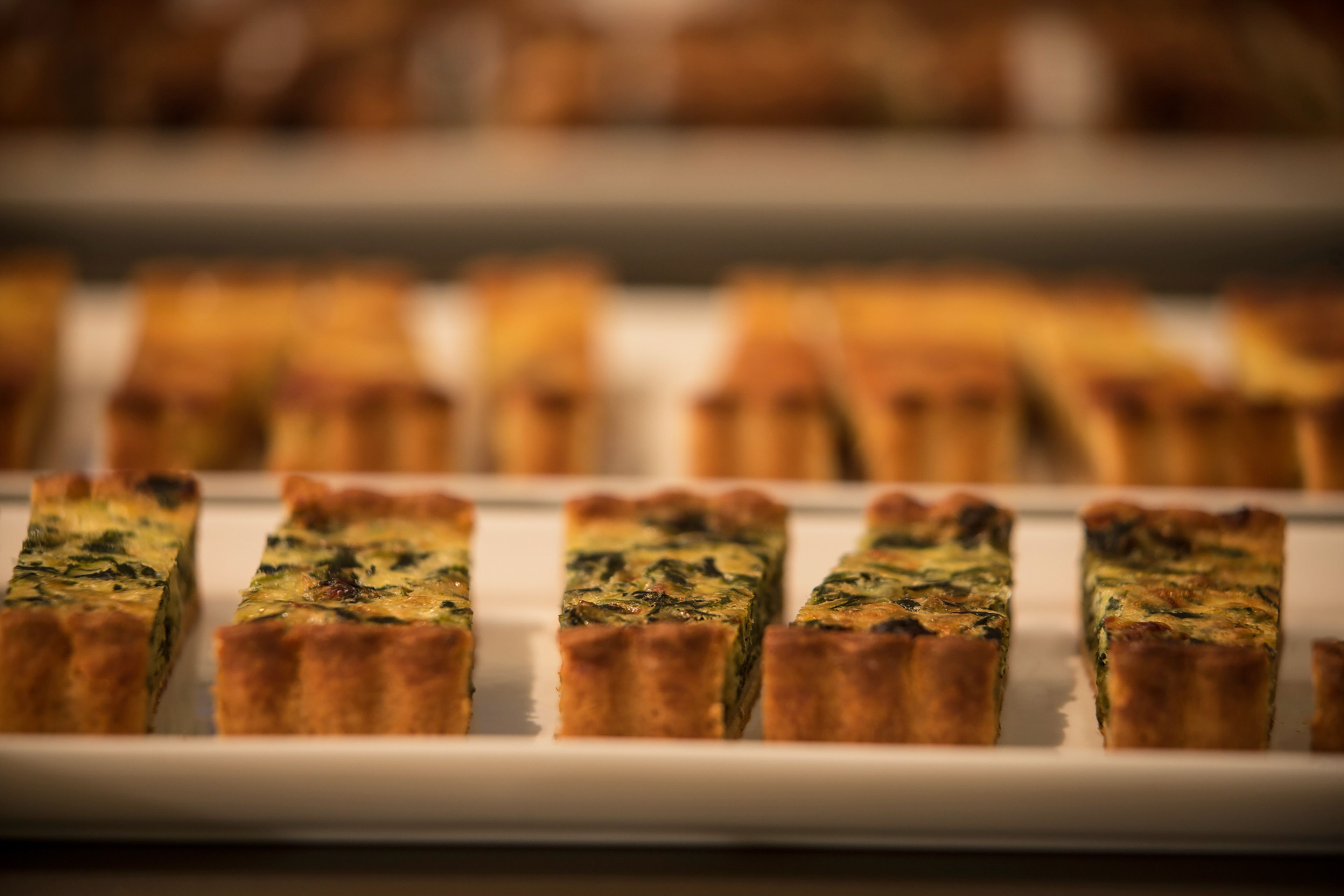 A tray of quiches arranged on a white plate.