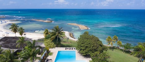 A resort with a swimming pool, beach, and ocean views.