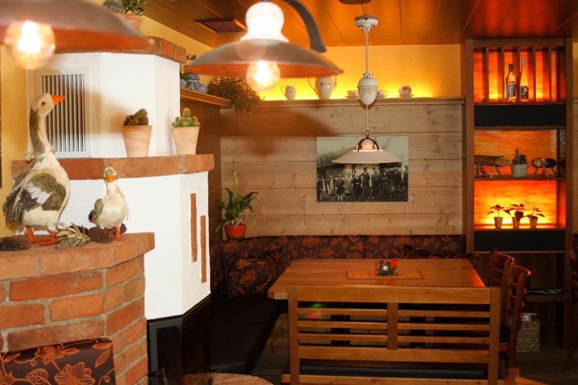L’intérieur chaleureux du restaurant est agrémenté d’une cheminée en briques, d’une table à manger en bois et de luminaires suspendus.