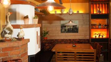 L’intérieur chaleureux du restaurant est agrémenté d’une cheminée en briques, d’une table à manger en bois et de luminaires suspendus.