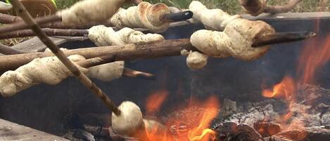 A campfire with logs and marshmallows being roasted.