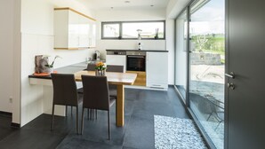 Eine moderne Küche mit Essbereich, ausgestattet mit einem großen Fenster und Blick ins Freie.