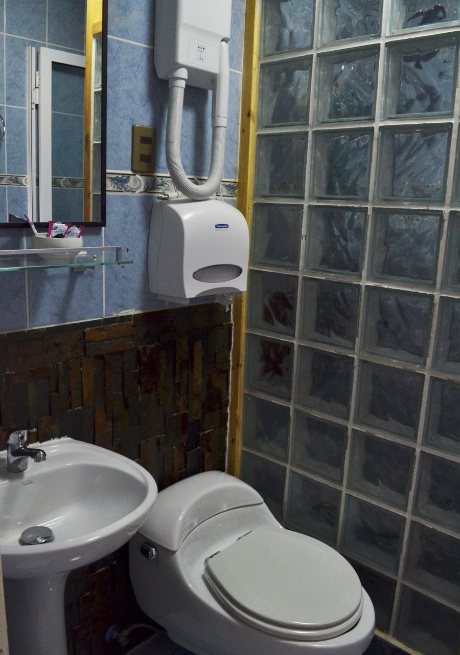 Ein Badezimmer mit Toilette, Waschbecken und einem Händetrockner.