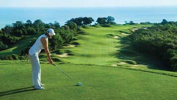 Un campo de golf con vista al océano.