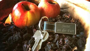 A bowl with two apples, a keychain, and dried flowers. - Suite an der Furt (Erfurt)