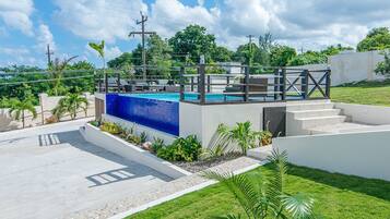 Una piscina al aire libre, sillones reclinables de piscina