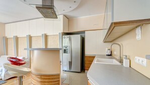 A modern kitchen with a built-in refrigerator, a sink, and a countertop. - Apartament Opera Sopot (Sopot)