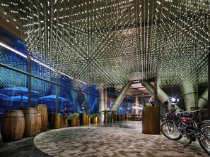 A spacious indoor area with a high ceiling adorned with hanging lights, large wooden barrels, and a motorcycle. - InterContinental Shanghai Wonderland by IHG (Shanghai)