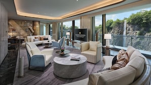 Een moderne hotel lobby met een ruime zithoek, een flatscreen televisie en een balkon met uitzicht op een waterval.