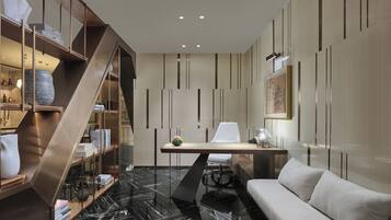 A modern interior with a marble floor, a sofa, a desk with a chair, and a bookshelf.