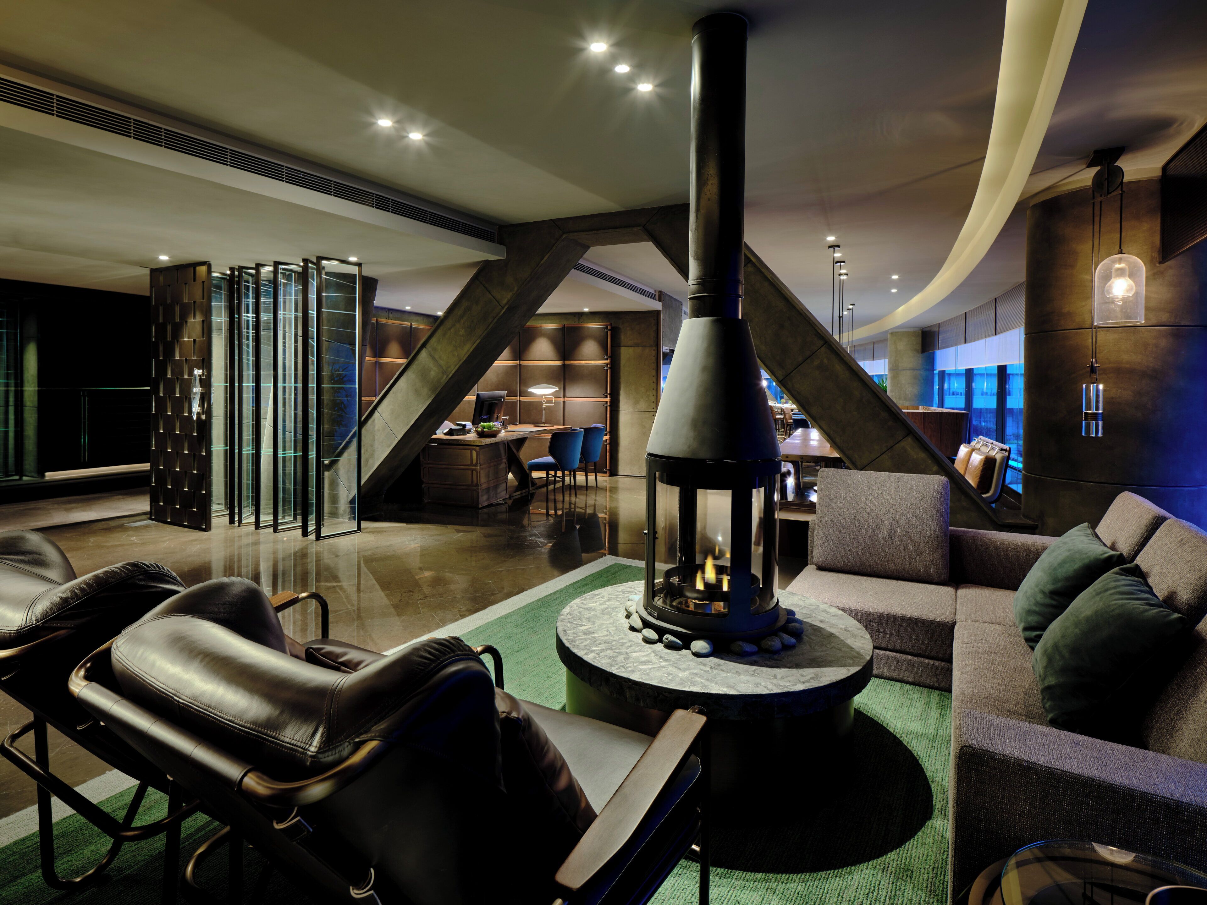 A modern interior with a central fireplace, leather seating, and a dining area.