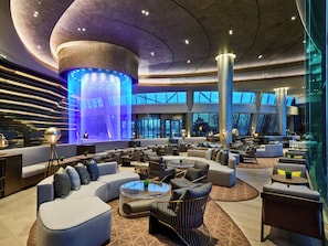 A spacious lobby with modern seating, a central water feature, and large windows. - InterContinental Shanghai Wonderland by IHG (Shanghai)