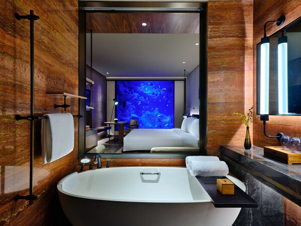 A modern bathroom with a large bathtub, a mirror, and a wall-mounted sink. - InterContinental Shanghai Wonderland by IHG (Shanghai)