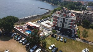 Un hôtel situé sur la côte, doté de plusieurs étages, d’une piscine et d’un parking.