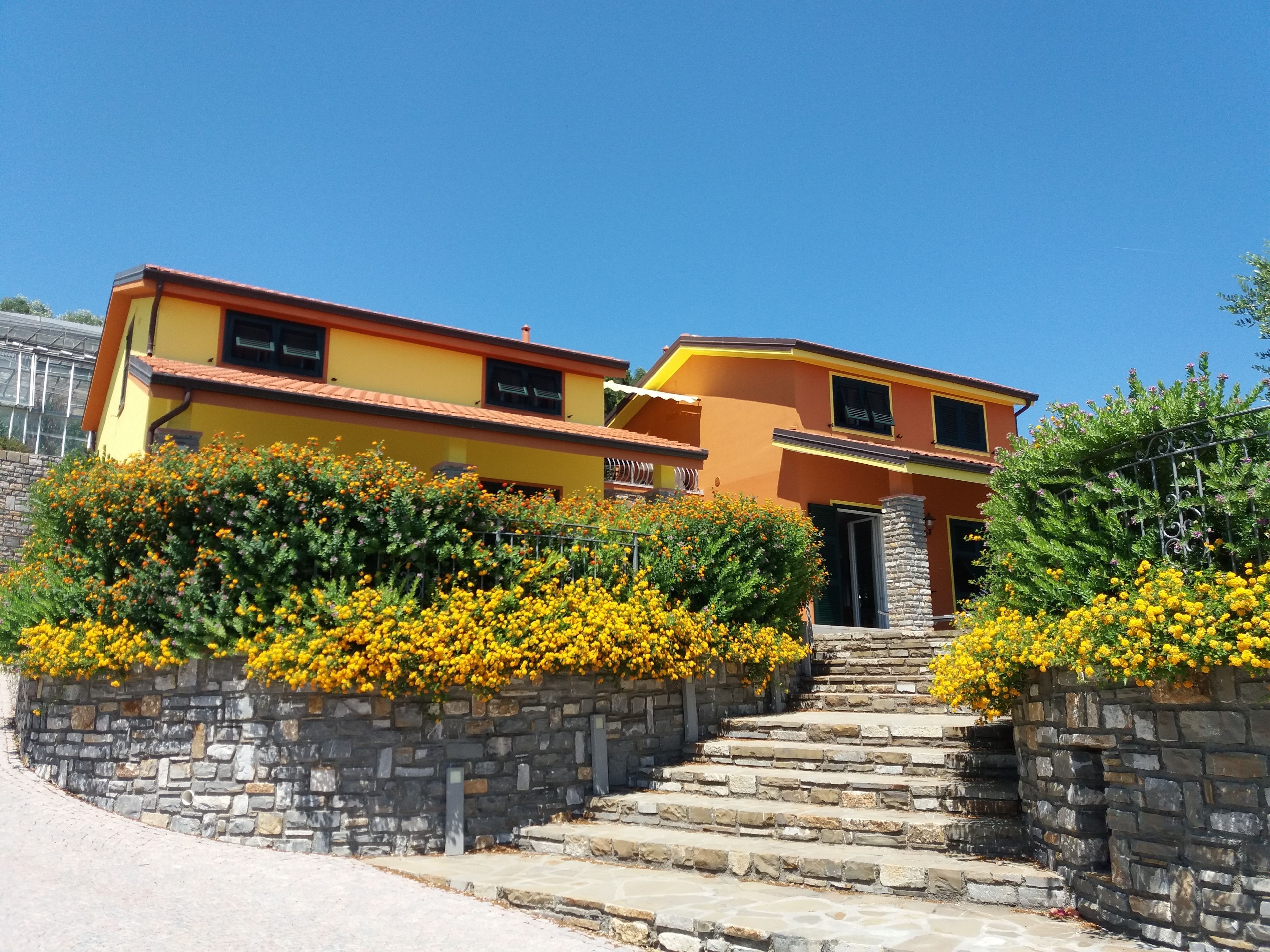 Un edificio de dos pisos con una escalera de piedra que lleva a la entrada.