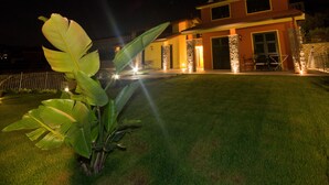 A modern house with a well-maintained lawn and stone pillars. - Agriturismo Le Girandole (Diano Marina)