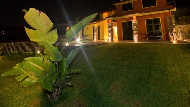 A modern house with a well-maintained lawn and stone pillars. - Agriturismo Le Girandole (Diano Marina)