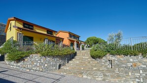 A two-story building with a yellow facade, stone steps leading to the entrance, and a metal fence. - Agriturismo Le Girandole (Diano Marina)
