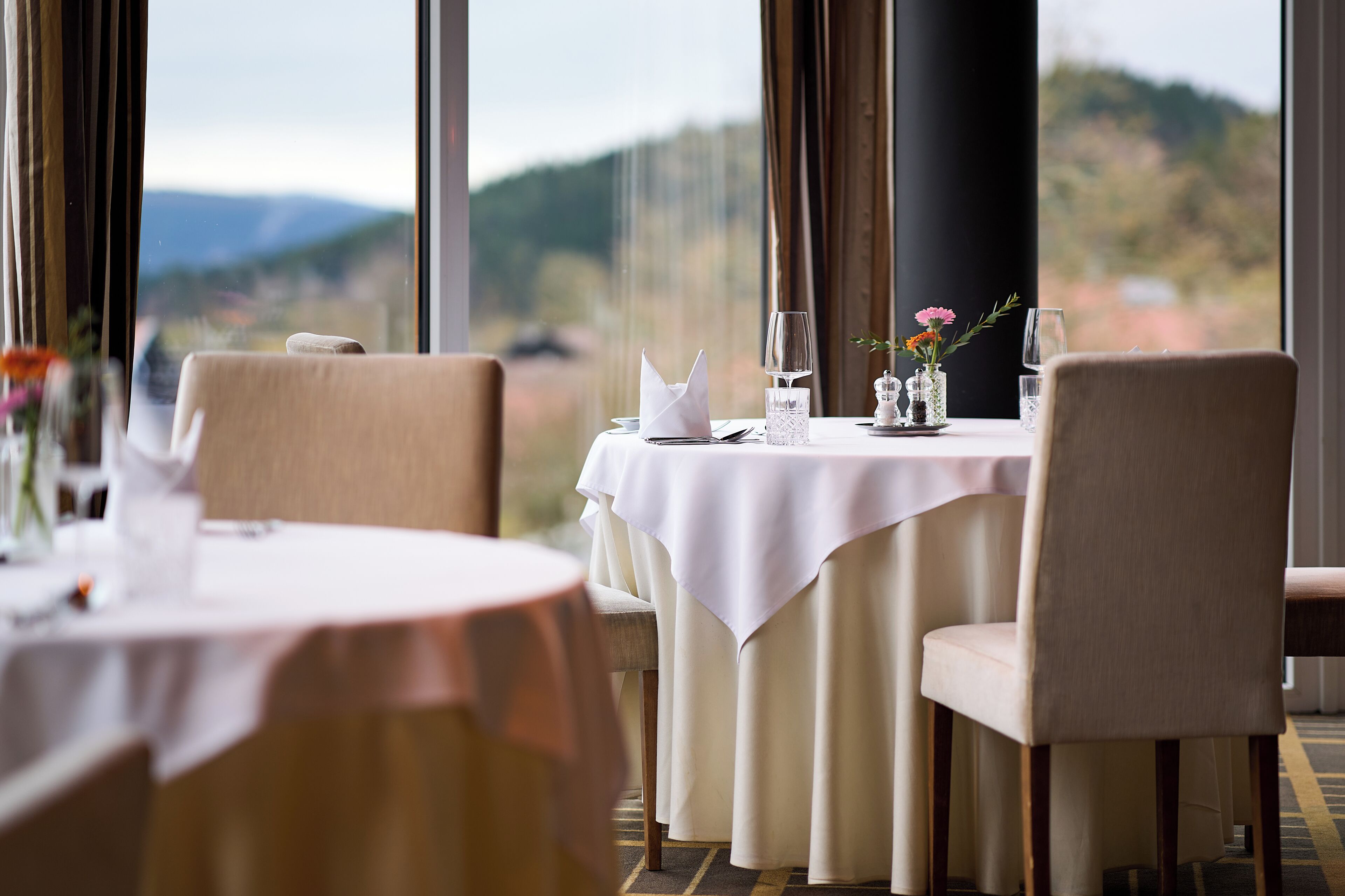 Una mesa de comedor dispuesta para dos, con vistas al campo.