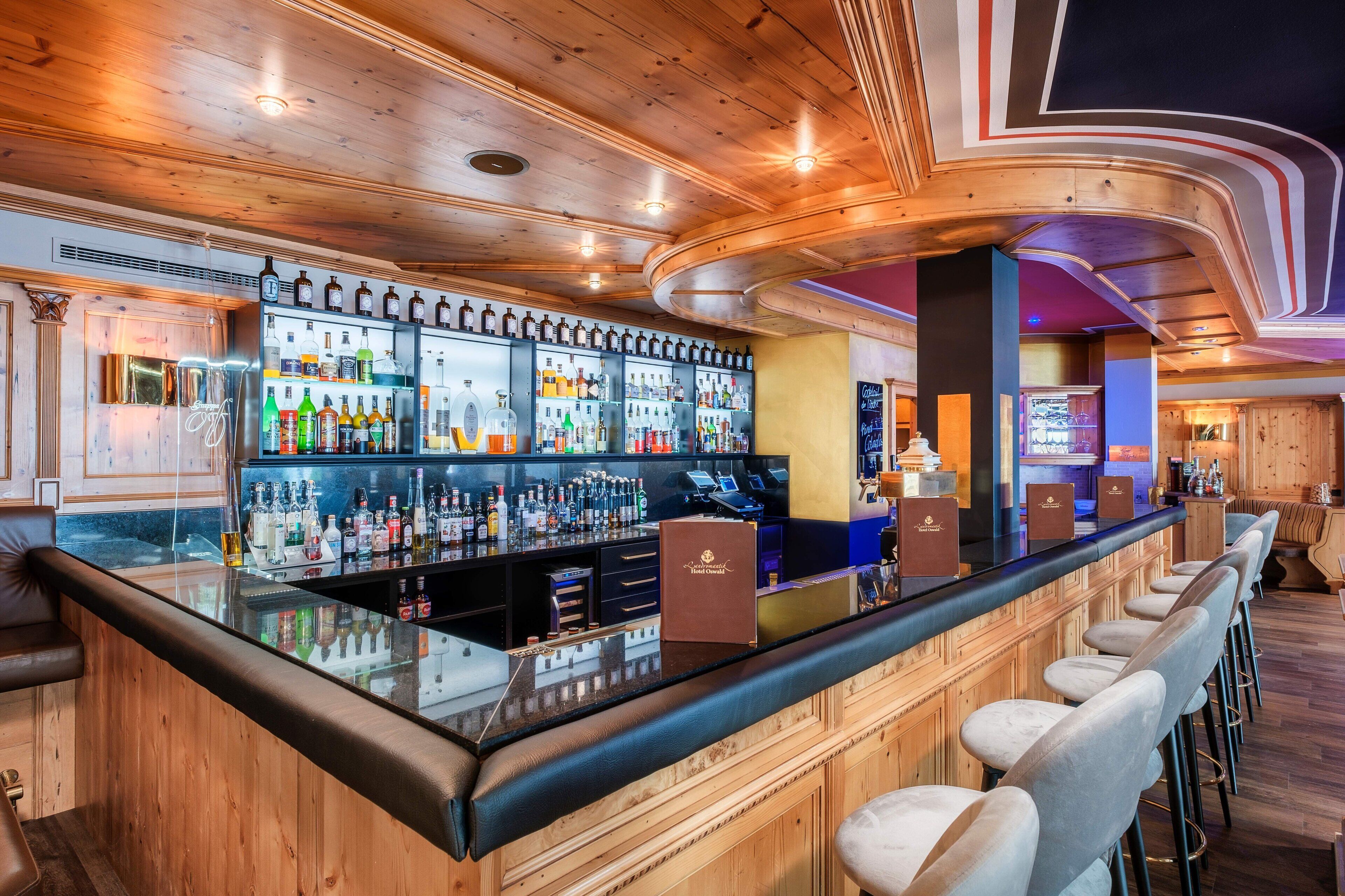 Un bar con interior de madera, una variedad de botellas y una barra.