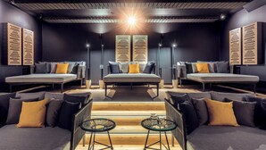 A modern room with a central bed, two sofas, and a small table with glasses. - Landromantik Hotel Oswald Gourmet & SPA (Teisnach)