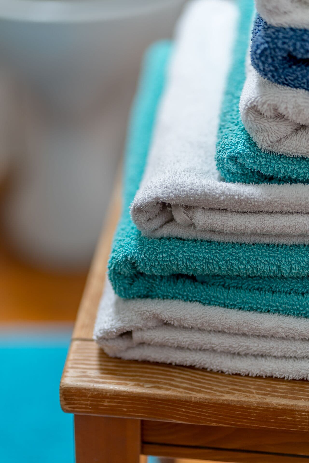 A stack of folded towels on a wooden table.