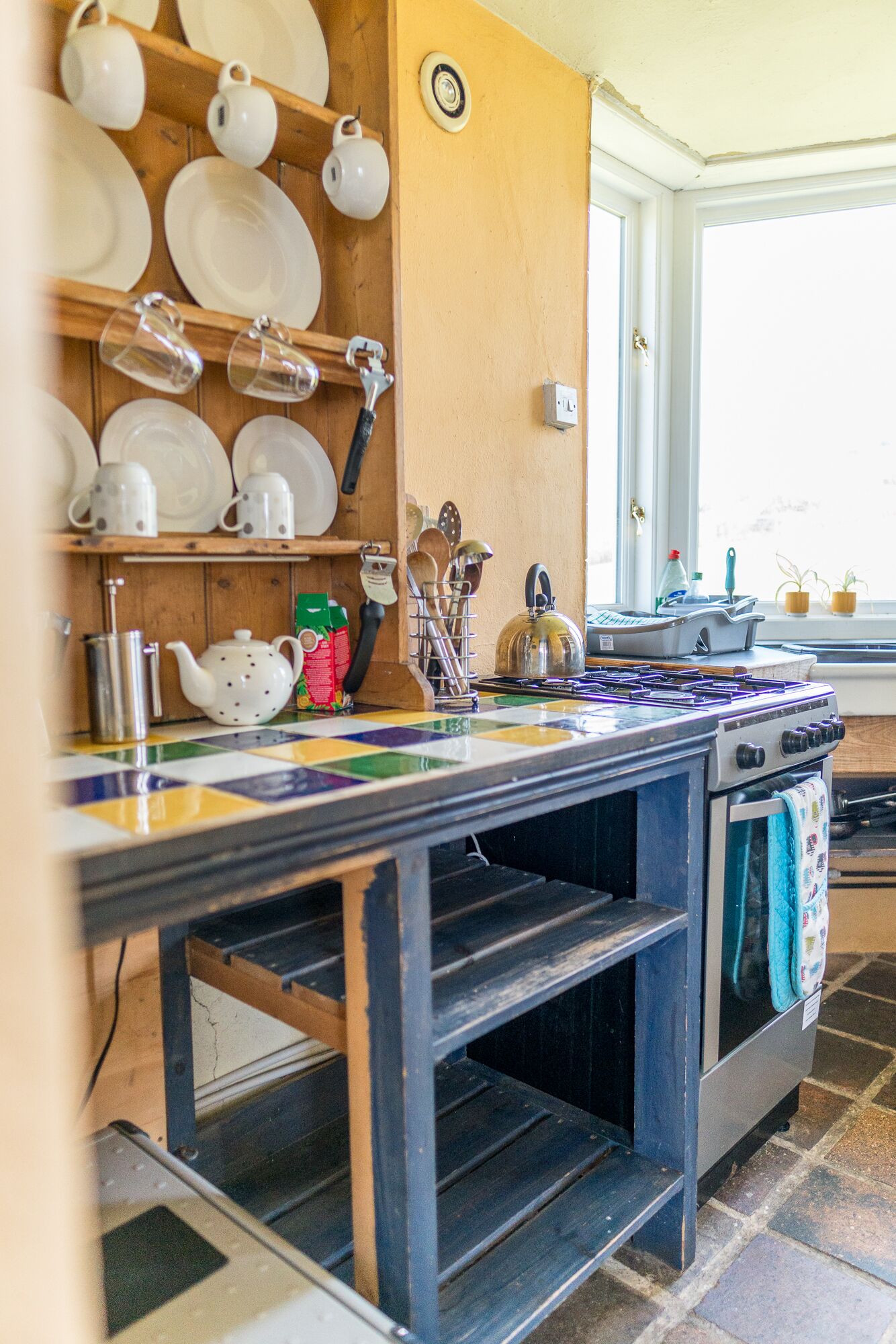 A kitchen with a stove, oven, and various utensils on the counter.