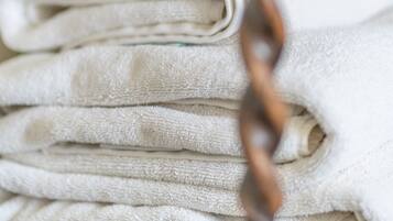 A stack of white towels on a wooden surface.
