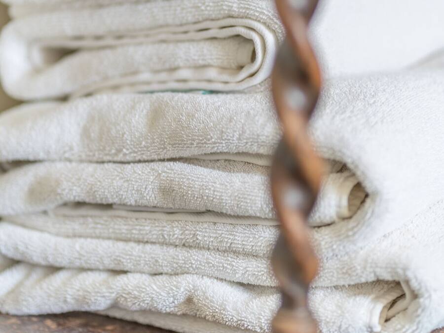 A stack of white towels on a wooden surface.