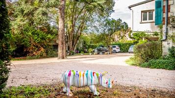 A residential street with a colorful painted rhinoceros sculpture in the foreground.