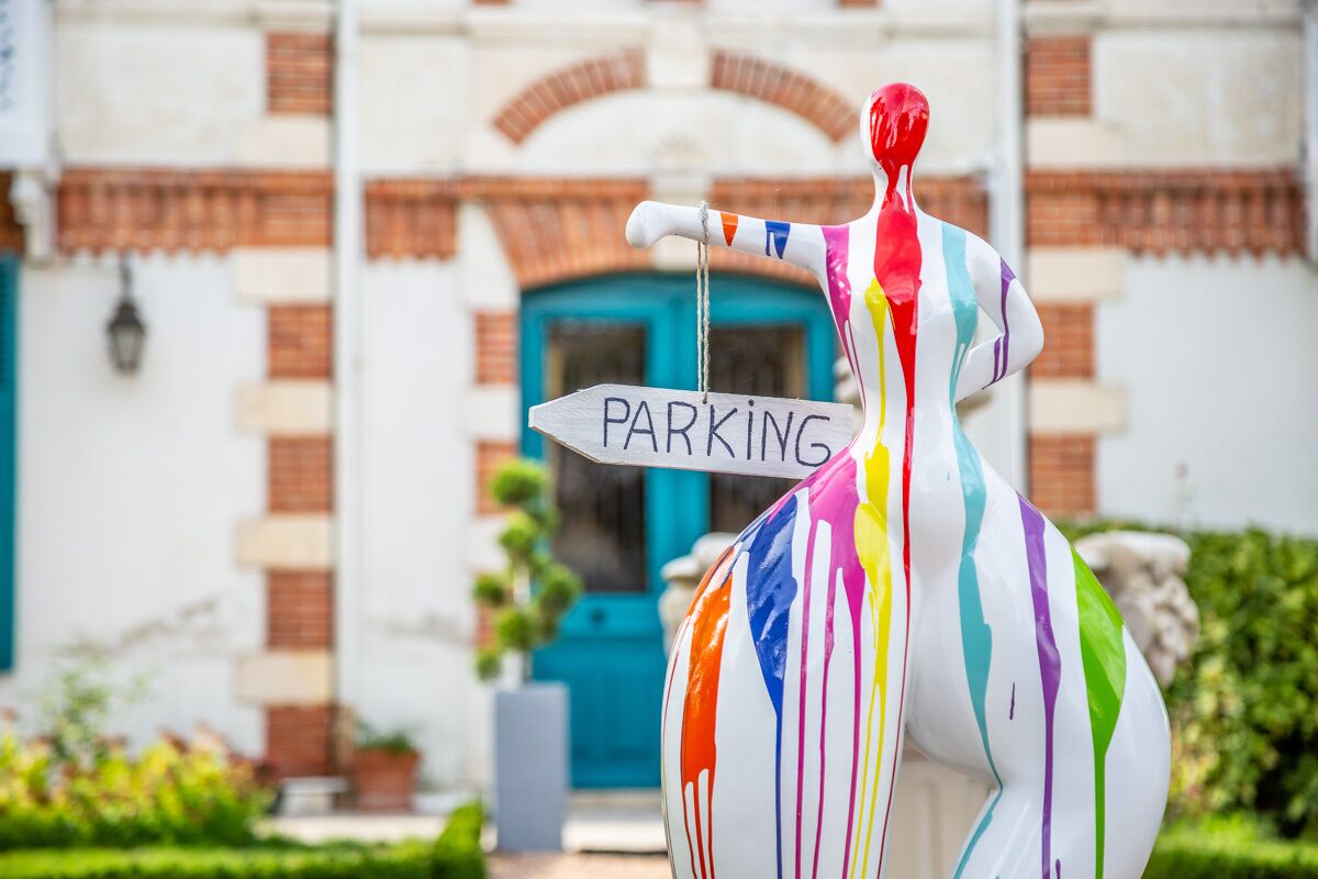A colorful sculpture with a 'PARKING' sign.