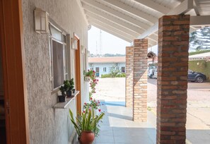 Relax in this serene outdoor space, surrounded by lush greenery and a brick pillar.