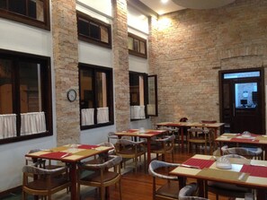 Dine in style with tables and chairs set amidst exposed brick walls and wooden furniture.