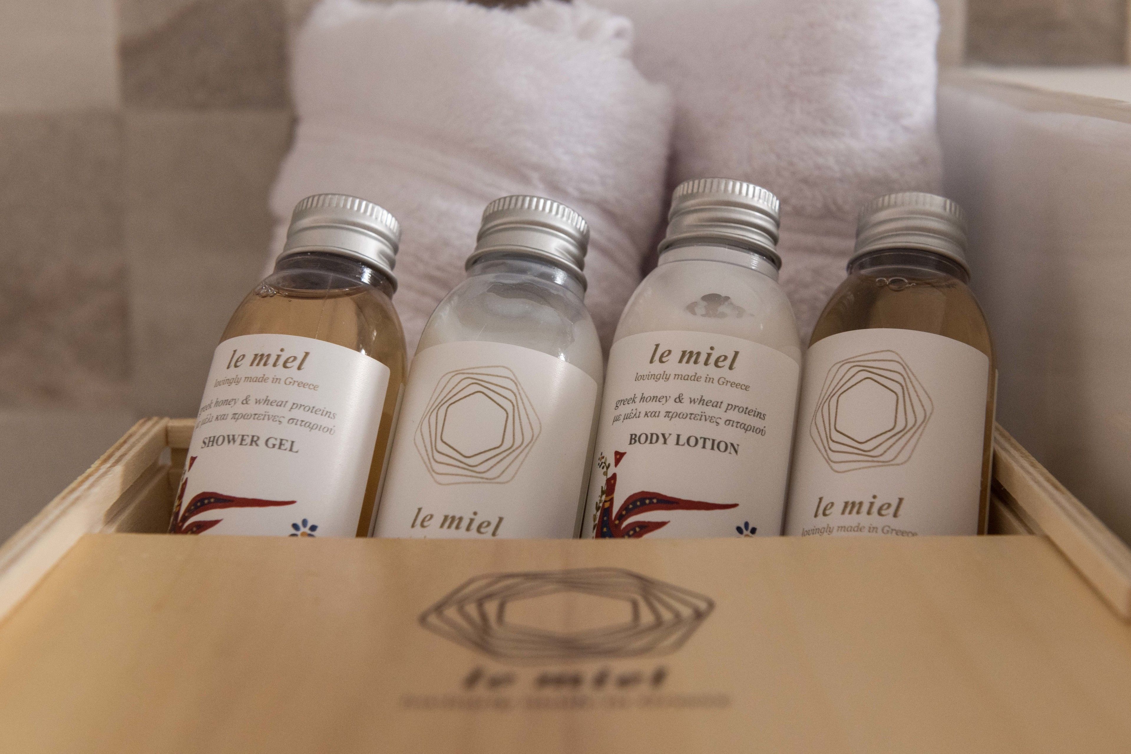 A wooden box containing four bottles of le miel body care products.