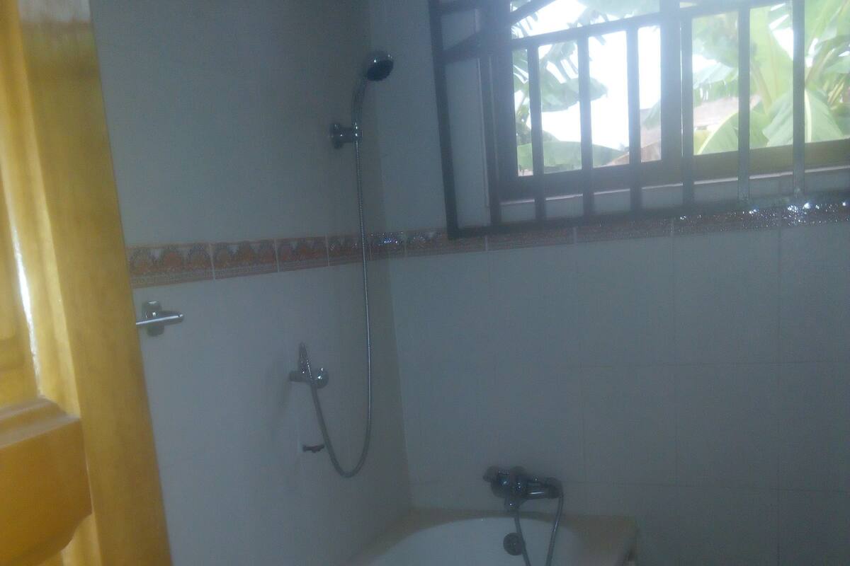 A bathroom with a bathtub, a shower, and a window.