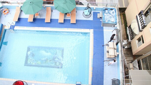 A rooftop pool with lounge chairs, umbrellas, and a hot tub. - Emmad Apartment Hotel (Addis Ababa)